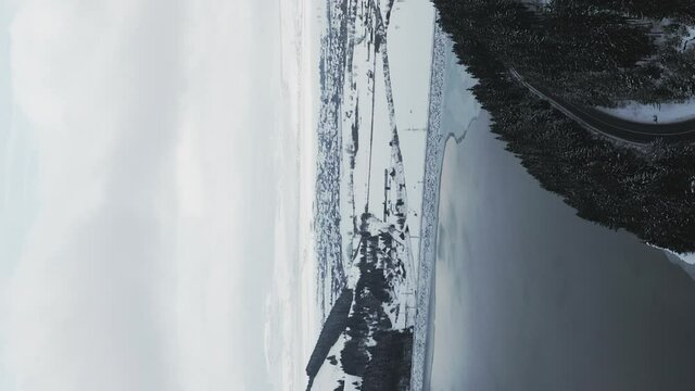 Aerial view of Frumoasa Dam area covered in winter snow. Romania. Vertical
