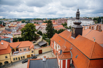 Pelhrimov, Czech Republic, 03 July 2021: Renaissance castle with red facade, mansard roof with prismatic turret and astronomical clock with moving figures at summer day, red tile roofs