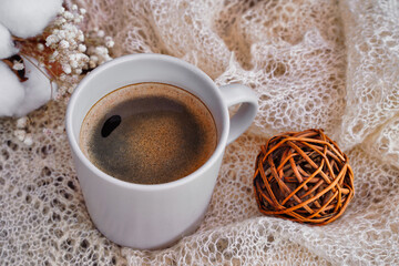 Cozy winter or autumn still life details, feminine white table with coffee, dried flowers and knitted scarf.