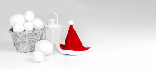 Santa Claus hat, snowballs and candlestick on a white background. Banner. Photo