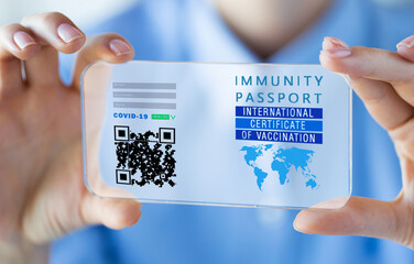 coronavirus, technology and health concept - woman's hands holding and showing transparent smartphone with virtual immunity passport or international certificate of covid-19 vaccination on screen