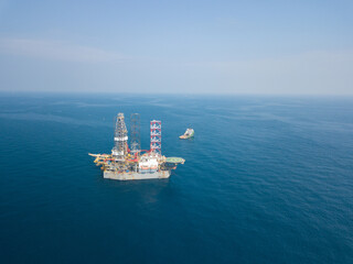 Offshore drilling rig (jack up rig) and tow vessels during the rig move operation in the middle of the ocean