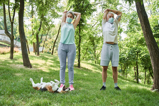 Spouses wearing protective masks feeling healthy while having morning exercises