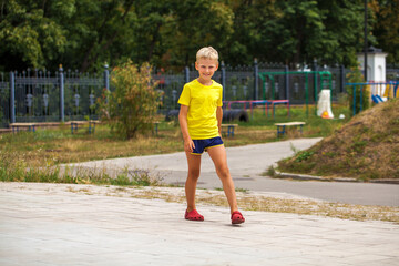 Blonde little boy in a summer park