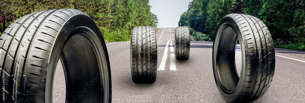 Wall mural summer tires roll on the asphalt road. the season of changing tires