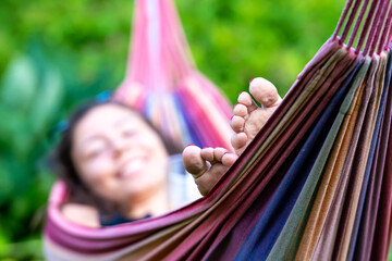 female is chilling and relaxing in the hammock, selective focus, focus on the feet