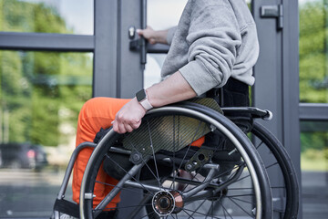 Fototapeta na wymiar Physically challenged girl moving herself at the wheelchair and opening doors