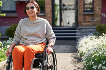 Girl with lower body disability looking away and smiling while enjoying of the summer
