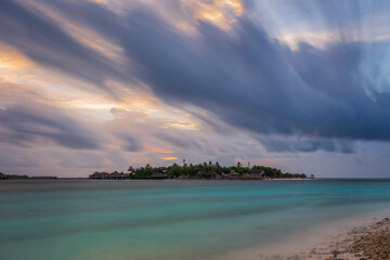Fototapeta na wymiar Tropical beach at resort, North Male Atoll, Republic of Maldives, Adaaran Prestige Vadoo resort hotel at sunset time. Long exposure picture in july 2021