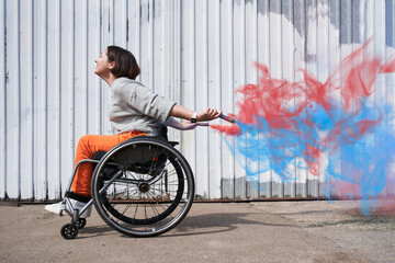Girl with loss of leg function moving herself at the wheelchair and smiling