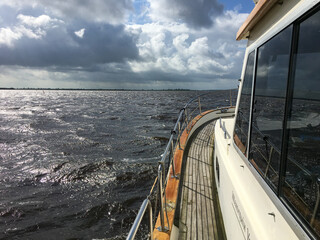 Lauwersmeer in the Netherlands with a dramatic cloudy sky above with part of a motor boat