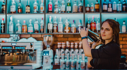 Portrait of young attractive woman bartender Making Cocktail Using Shaker in bar