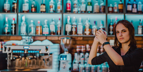 Portrait of young attractive woman bartender Making Cocktail Using Shaker in bar