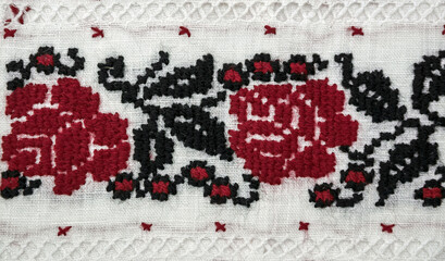 Traditional Ukrainian embroidery. Red and black roses on linen fabric