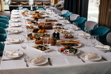 Glasses and plates on long table in restaurant for celebration