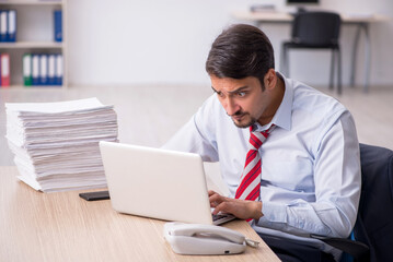 Fototapeta premium Young male employee sitting at workplace