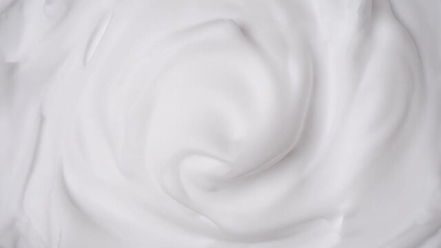 Foam swirl. Close view of thick shaving foam. Top view. Rotation