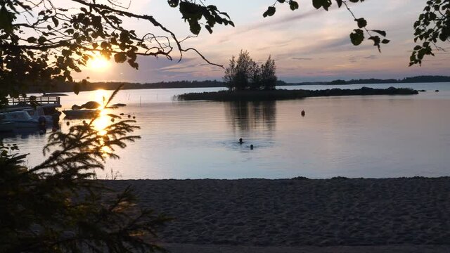 Stockholm archipelago past midnight, Couple swim at peaceful deserted beach