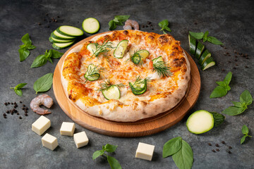 Vegetable pizza with seafood and cheese on dark background. Ingredients around.