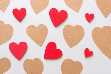 brown paper sticker hearts and hand painted red hearts on a light gray paper background