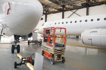 Passenger airplane on maintenance repair check in airport hangar indoors. Aircraft. Plane, shipping, transportation concept