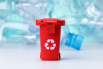 Red Garbage Can On Many Used plastic Bottles Background. Recycling problem.