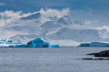 Blue iceberg with mountain backdrop