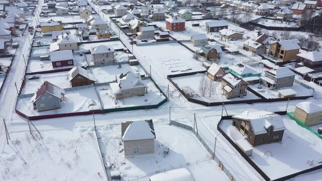 Aerial view of cottages under snow. Russian dacha houses in winter
