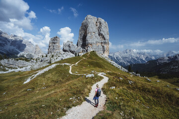 Fototapeta na wymiar Hiker with backpack explore Cinque Torri mountains in Dolomites, Italy