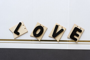 the word "love" on plain wood tags on fancy paper with space for text