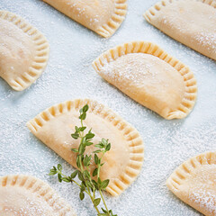 Raw Empanadillas, small filling tuna pies, tomato sauce, bell pepper, boiled egg. Before to baked in oven. Cooking process. Close up. Mediterranean Spanish food. Selective focus.