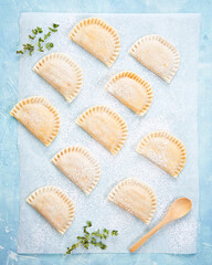 Raw Empanadillas, small filling tuna pies, tomato sauce, bell pepper, boiled egg. Before to baked in oven. Cooking process. Mediterranean Spanish food.
