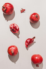 Fresh pomegranates on pastel grey background with sunlit. Minimal style. Top view. Flat lay .