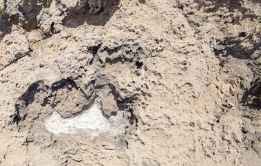 the sea coast in the form of bottom sediments flooded with seawater with the formation of salt patterns and sea lagoons in the form of textures and stone abstractions under water with shadows from the