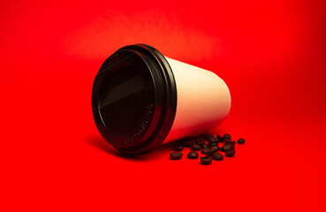 white paper cup with coffee beans on a red background