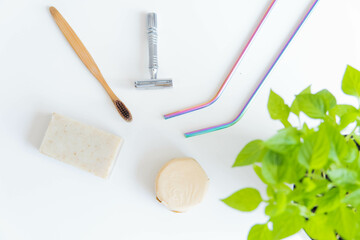 Fototapeta na wymiar Zero waste product, close up caption. Bamboo toothbrush, solid shampoo, metal razor, metal straws and solid hand soap. Sustainable bathroom products on a white background.