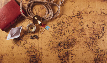 Happy Columbus Day concept. Vintage compass, paper boat, rope on retro treasure manuscript.  Flat...