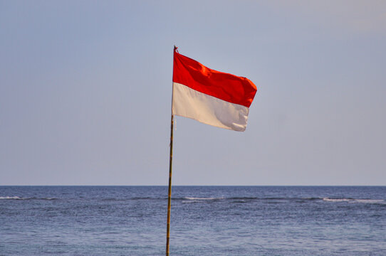 Indonesia's flag waving against bkue sky and ocean