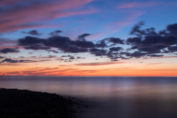 Fototapeta na wymiar glass calm lake with vibrant colors of a sunset sky