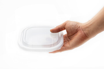 A plastic box in hand for holding food on a white background