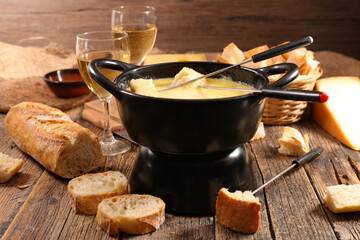 cheese fondue with bread and wine glasses