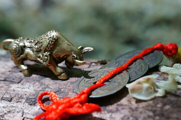 A metal bull figurine and a bunch of Chinese coins.