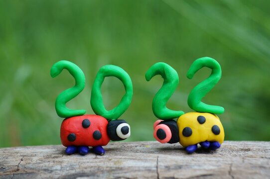 Two ladybugs and the number 2022 from plasticine close-up.