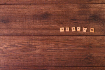 Frases motivadoras con letras naturales sobre una mesa o suelo de madera rustica.