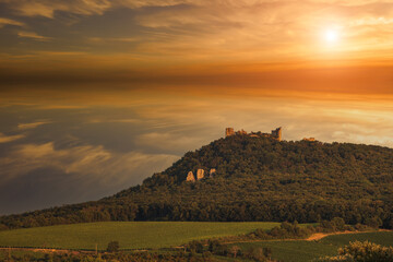 Obraz premium The ruins of the Devicky castle in the Palava region in South Moravia in the Czech Republic. There are clouds in the sky at sunset.