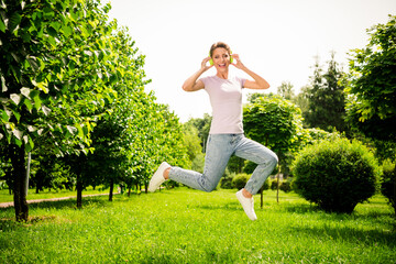 Full length body size view of attractive carefree cheerful girl jumping listening hit on fresh air outdoors