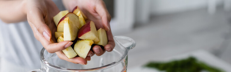 cropped view of female hands with cut apple near jar of shaker, banner.