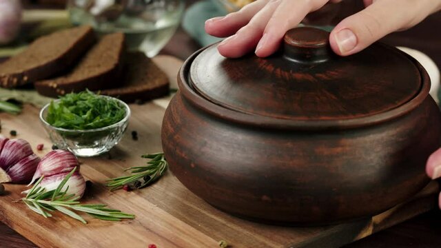 Putting boiled borsch on board and opening close-up, cooking soup made of beetroot. Traditional Russian Cuisine. Ukrainian food in wooden bowl. Fresh homemade dish.