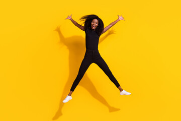 Fototapeta na wymiar Full length body size photo of curly girl jumping high careless isolated on bright yellow color background