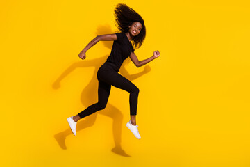 Fototapeta na wymiar Full size profile side photo of happy nice young dark skin woman jump up runner sale isolated on yellow color background